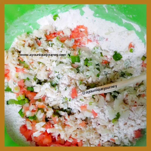 Mixing the flour mixture, vegetables and saltfish together.