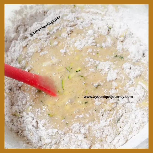 Adding the dry ingredients to the wet ingredients to make the Zucchini Bread mixture.