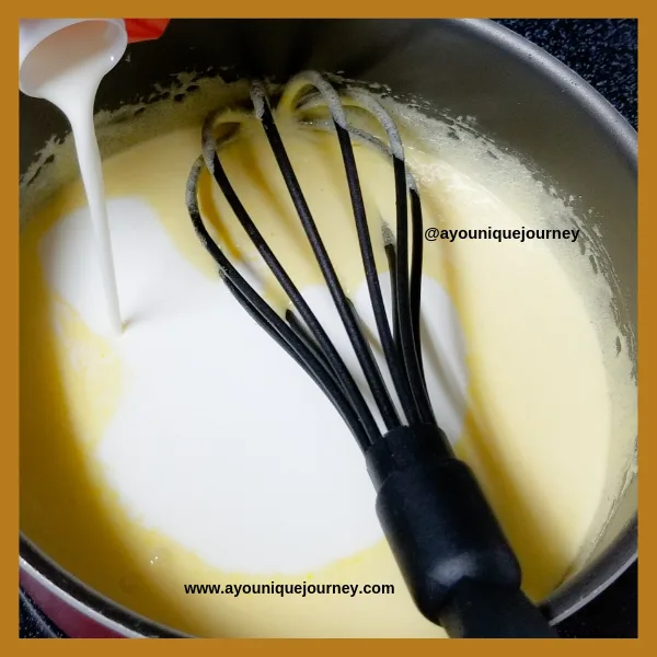 Adding the heavy cream to the cooked egg base to make the Stout Ice Cream.