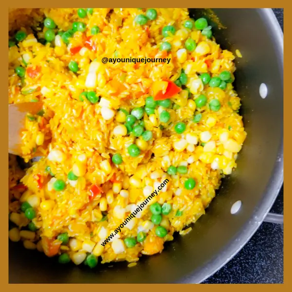 Adding the frozen sweet corn and sweet peas to the yellow coated rice and sauteed vegetables.