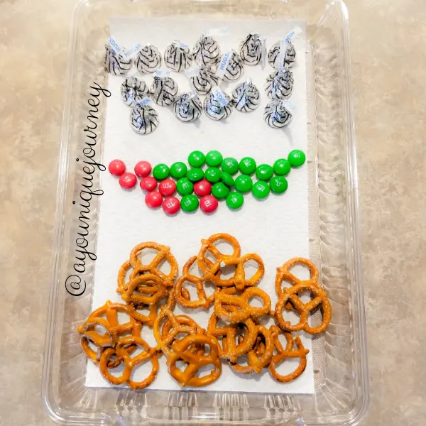 The ingredients to make Christmas Pretzel Treats: Pretzels, Green & Red M&M and Hershey's Hugs.