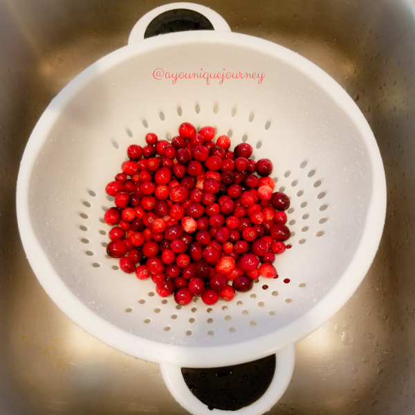 Rinsing the cranberries and removing the ones that are not needed.