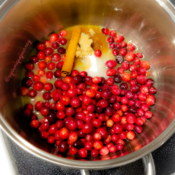 Adding the vanilla stick, orange juice, water, pinch of salt and sugar to make the Cranberry Sauce.