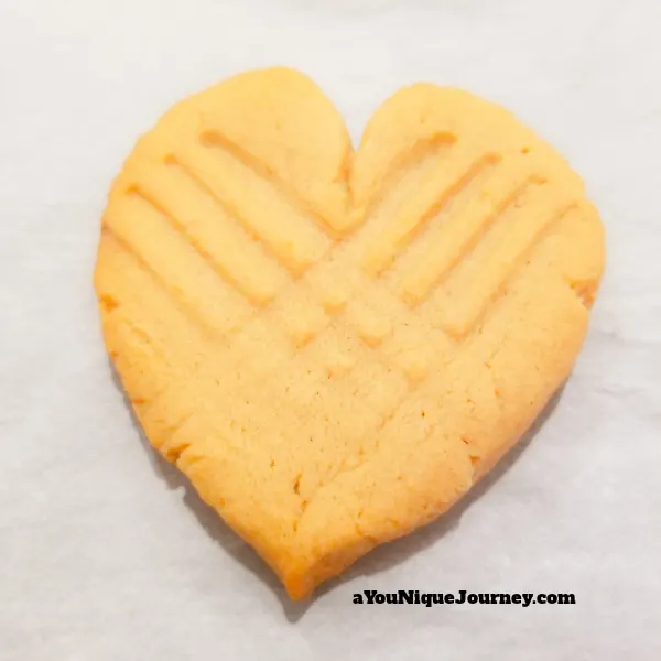 A heart shaped peanut butter cookie after baking.