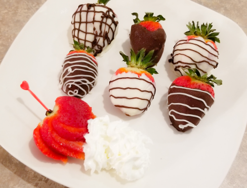 Chocolate Covered Strawberries on a white plate with some whip cream