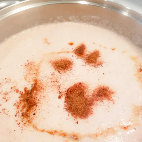 Adding the nutmeg and vanilla extract to the peanut porridge.