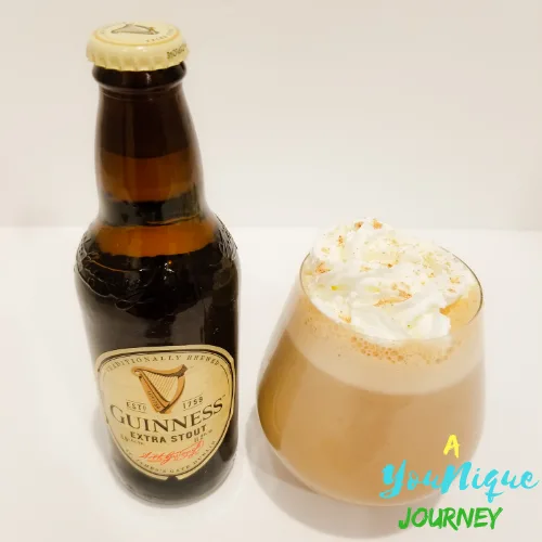 A glass of Guinness Punch with a bottle of Guinness Stout.