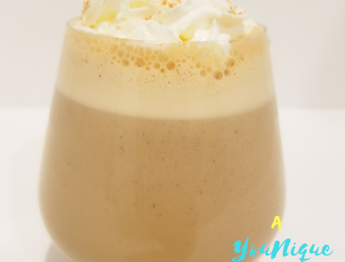 Guinness Punch Recipe in a glass with whipped cream and grated nutmeg on top.