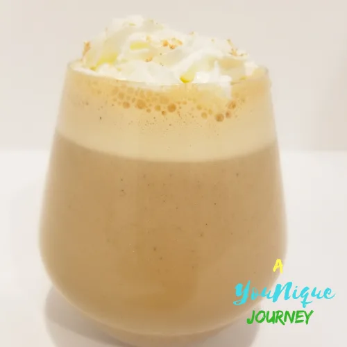 Guinness Punch Recipe in a glass with whipped cream and grated nutmeg on top.