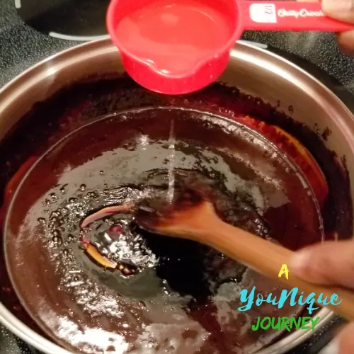 Adding the boiling water to the dark melted sugar to make the Homemade Browning Sauce.