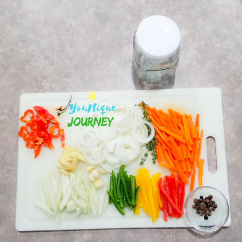 All the cut vegetables, herbs and spices before adding them to the jar to make the Jamaican Escovitch Pickle Sauce.