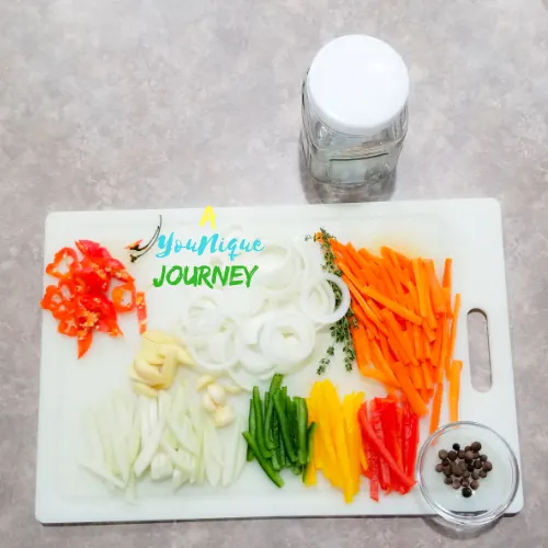 All the cut vegetables, herbs and spices before adding them to the jar to make the Jamaican Escovitch Pickle Sauce.