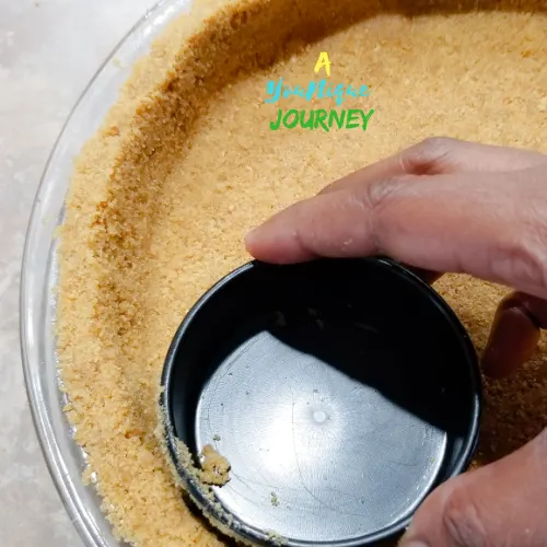 Pressing down the crust with a measuring cup into the pie dish.