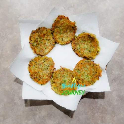 Zucchini Fritters on a plate lined with paper towel after frying.