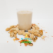 A glass of Peanut Punch with peanuts in shells around it.