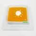 Pumpkin Soup with roasted pumpkin seeds and a dollop of sour cream on top in a white square bowl.