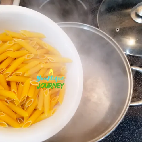 Cooking the penne pasta as instructed on the package.