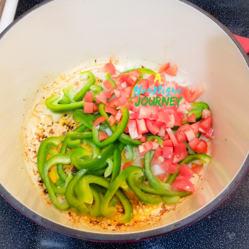 Adding the garlic, onions, bell peppers and tomatoes sautéing after removing the chicken pieces.