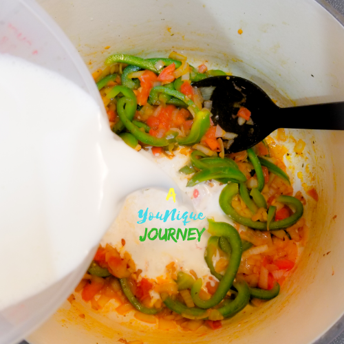 Adding the cream to the sautéed vegetables.