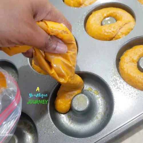 Add the pumpkin batter into each donut cups to make the baked pumpkin donuts.