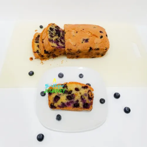 A slice of blueberry bread on a small white plate.