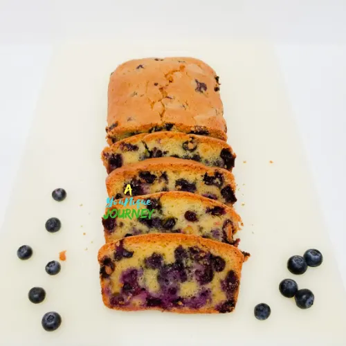 A sliced blueberry brad with blueberries at the sides.