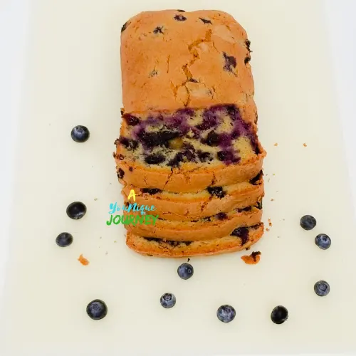 a loaf of Blueberry Bread on a white cutting board.