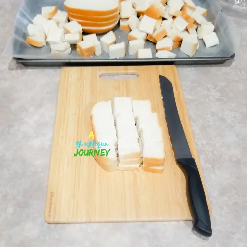 Cutting bread cubes from the hard dough bread to make eggnog bread pudding.