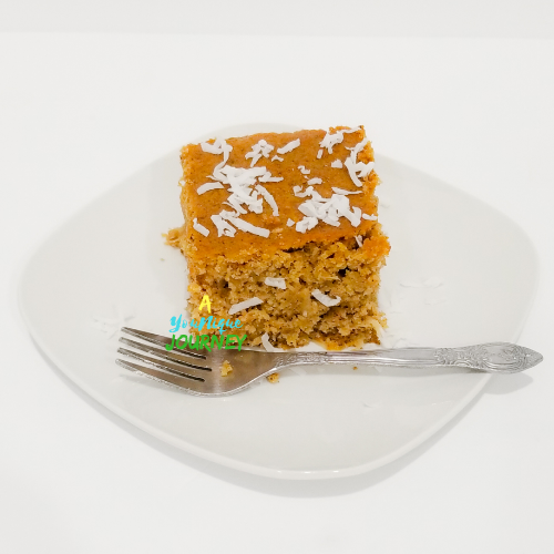 A slice of Jamaican Toto Coconut Cake on a white plate.