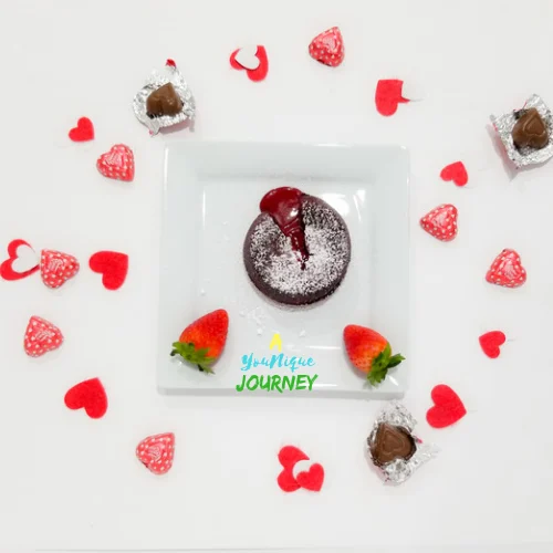 Red Velvet Lava Cake and strawberries on a serving plate with heart shaped chocolates and felt hearts.