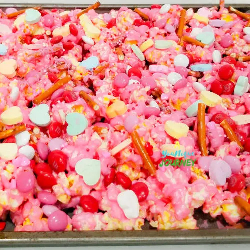 After adding the remaining broken pretzels, M&M's cupid mix, Conversation Hearts and Sprinkles to make the Valentine's Day Popcorn Mix.