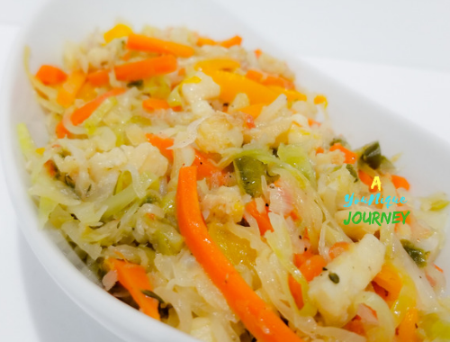 Saltfish and Cabbage Recipe in a white serving bowl.