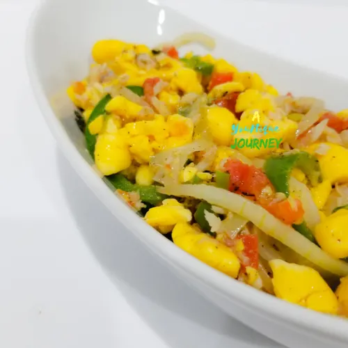 A closer look at the ackee and saltfish in a white serving bowl.