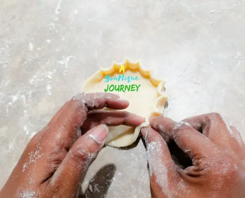 Pinching the edges of the crust to make a casing.