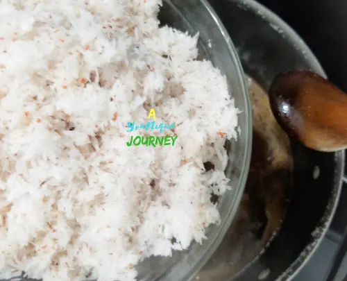 Adding the grated coconut to the liquid mixture.