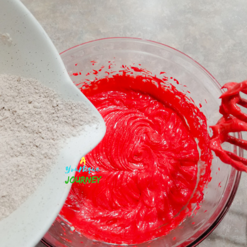 Pouring the dry ingredients to the mixture to make the Red Velvet Cake.