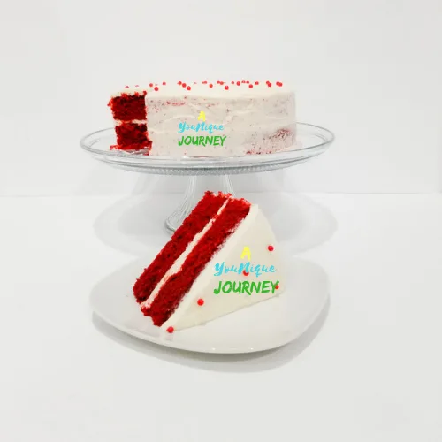 Red Velvet Cake on a cake stand with a slice on a white plate.