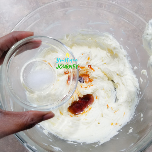 Adding salt to the cream cheese mixture.