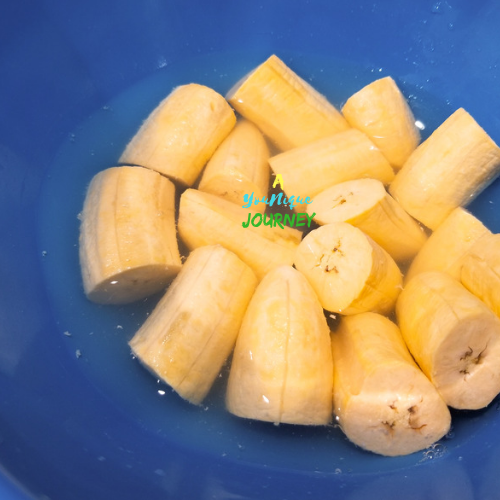 Green plantains soaking in the water mixture.