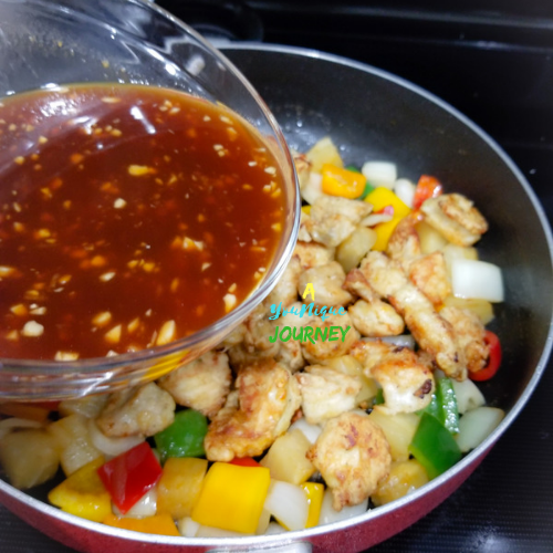 Pouring the sauce to the chicken pieces and sautéed vegetables. 
