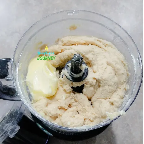 Add the softened butter to the mixture to finalize the dough for the Jamaican Hard Dough Bread Recipe.