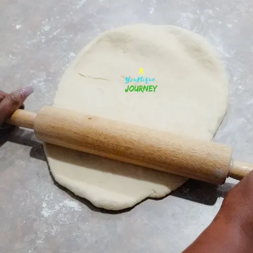 Using a rolling pin to roll out the dough into a rectangle shape to make the Jamaican Hard Dough Bread.
