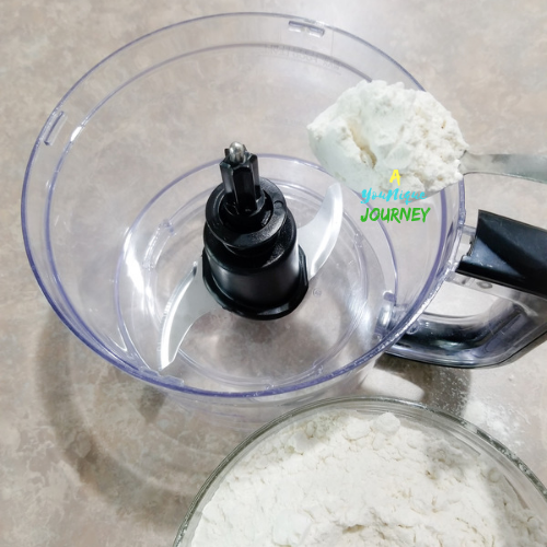 Adding the all purpose flour to the food processor to make the Jamaican Hard Dough Bread