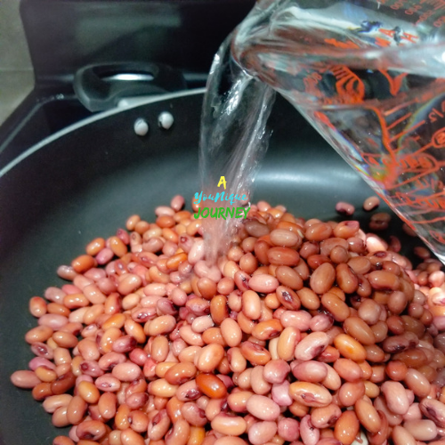Adding fresh water to the soaked beans.