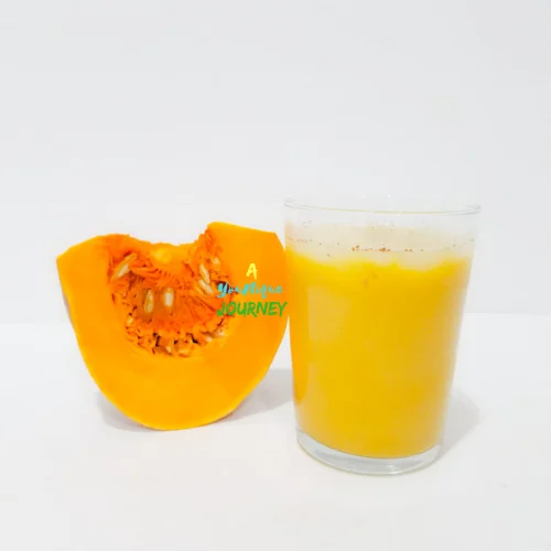 A glass with Jamaican Pumpkin Punch with a piece of pumpkin.