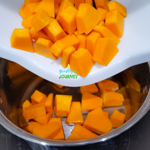Adding the pumpkin cubes to a pot to make Jamaican Pumpkin Punch.
